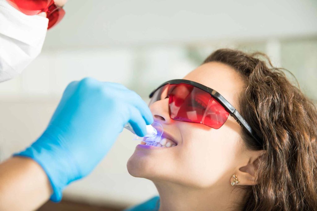 Mujer haciéndose un blanqueamiento dental en una clínica de odontología